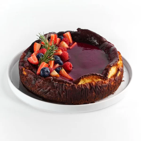 Tarta cremosa de queso quemado con salsa de zarzamora al vino tino.