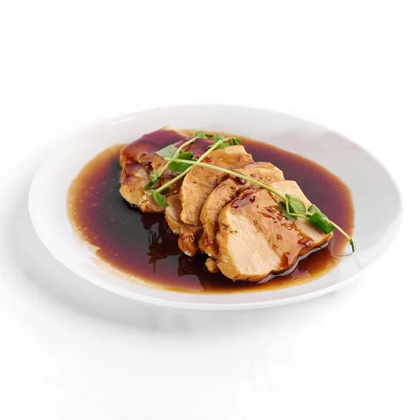Pechuga de pavo rebanada con salsa agridulce de frambuesa y chipotle.