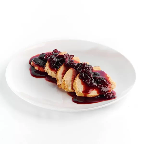 Pechuga de pavo rebanada con gravy de arándanos y vino tinto.